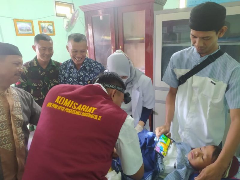 Foto : salah satu peserta peserta sunatan masal sedang di sunat di saksikan kepala desa Battu Winangun Yadi dan Babinsa desa