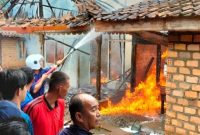 Foto: Petugas Pemadam Kebakaran Berupaya Memadamkan api dirumah yang terbakar