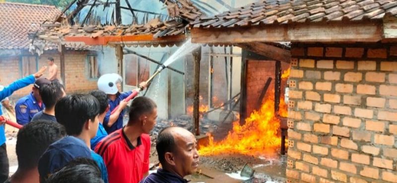 Foto: Petugas Pemadam Kebakaran Berupaya Memadamkan api dirumah yang terbakar