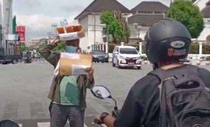 Baharuddin Kamba, warga Yogyakarta yang juga aktivis dan pemerhati sosial menggelar aksi teatrikal berjualan es teh di kawasan titik nol kilometer Malioboro, Kamis (5/12/2024).