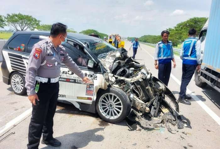 foto: anggota polisi sedang menunjukkan keadaan kendaraan usai kecelakaan