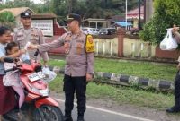 foto : Kapolsek Semidang Aji, Ipda Meyke Krisdian Hasri, S.H., memberikan takjil kepada warga yang melintas di depan kantor Polsek Semidang Aji