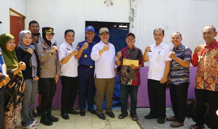 Keluarga korban kebakaran bersama Ketua RW dan RT, Lurah Kadipaten, Mantri Pamong Praja Kraton, Dinas Pemadam Kebakaran dan Wali Kota Yogyakarta Hasto Wardoyo berfoto dengan salam semangat untuk membangkitkan semangat warga