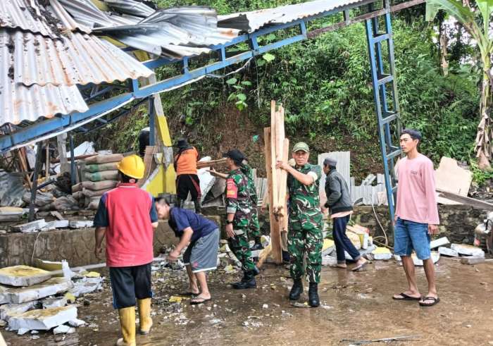 foto: warga bantu membersihkan bangunan yang di terjang tanah lonsor bersama TNI dan Polri