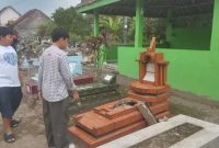 foto: Seorang warga sedang melihat makam keluarganya yang dirusak