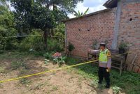 foto:  seorang anggota polisi menunjukkan penemuan mayat di bawah pohon nangka